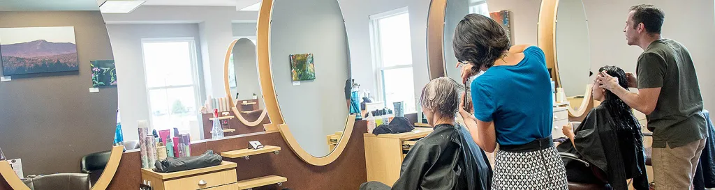 Salon shop with hairdresser cutting a customer's hair.